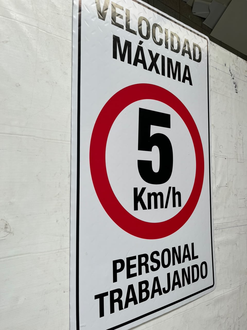 Señal de velocidad máxima 5 km/h con personal trabajando